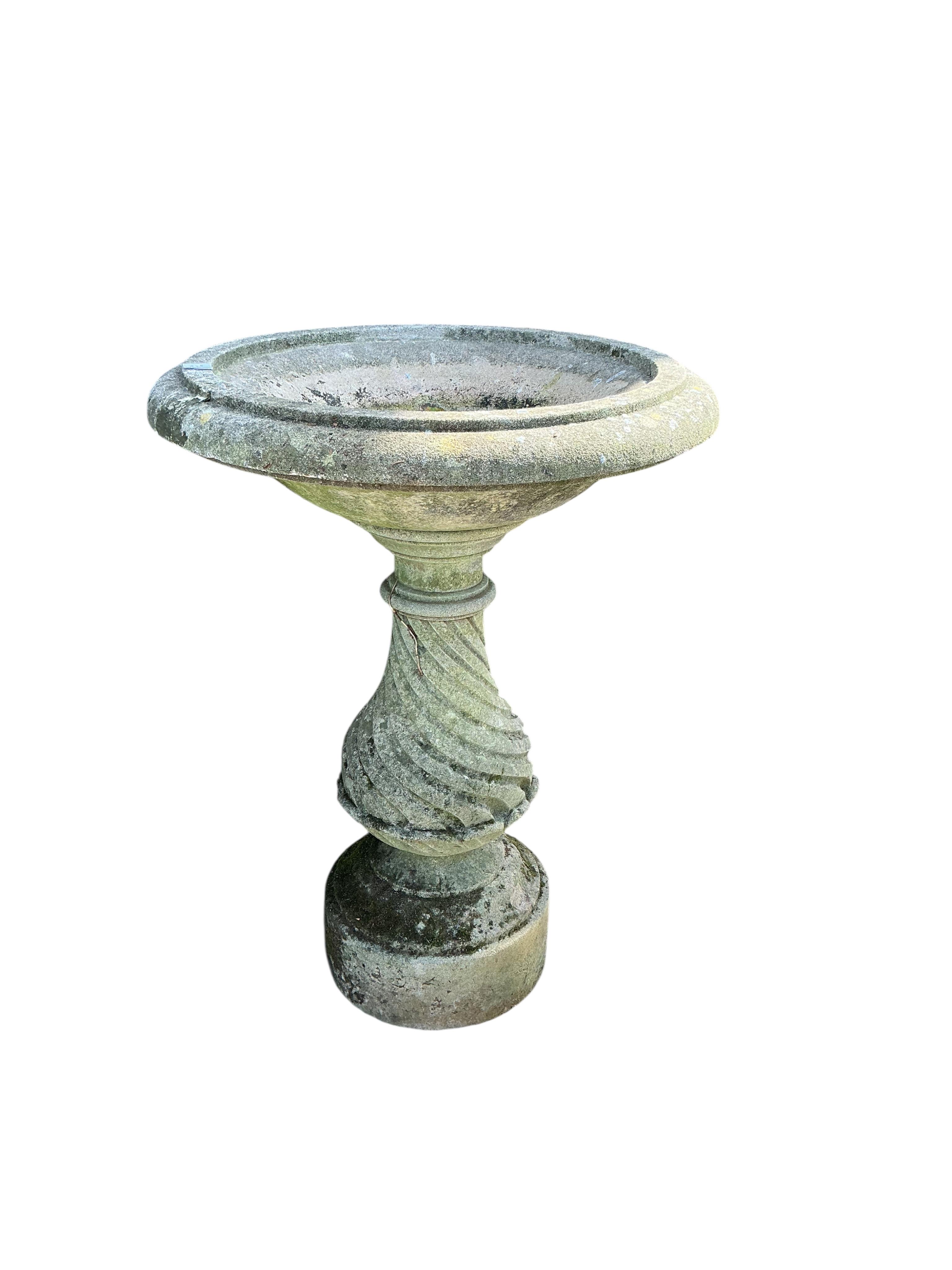 A circular reconstituted stone birdbath, diameter 68cm, height 92cm